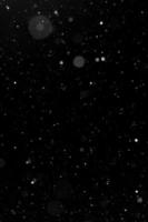 Bokeh weißer Schnee auf einem schwarzen Nachthintergrund foto