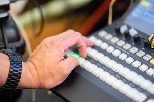 Konzentrieren Sie sich auf die Hand des Menschen, wie Sie das Livestreaming-Switcher-Board steuern. foto