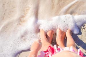 Closeup Mutter und Kind Füße am weißen Sandstrand foto