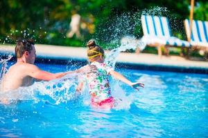 glückliche familie, die gemeinsam spaß im außenschwimmbad hat foto