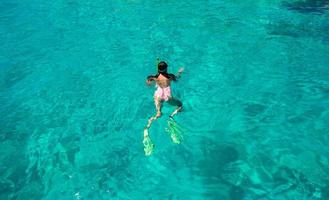 junge Frau, die im Urlaub im tropischen Wasser schnorchelt foto