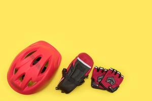 radfahrerzubehör auf gelbem hintergrund - helm, fahrradtasche, handschuhe mit copyspace foto