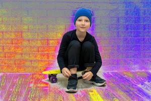 Junge mit Hut zieht seine Turnschuhe hoch, während er im Neonlicht auf einem Skateboard sitzt foto