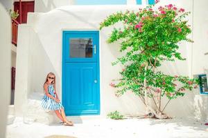 entzückendes kleines Mädchen in der alten Straße des typischen griechischen traditionellen Dorfes foto