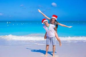 glückliches paar mit weihnachtsmütze viel spaß am karibischen strand foto