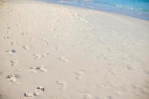 menschliche Fußabdrücke am weißen Sandstrand foto