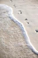 menschliche Fußabdrücke auf weißem Sand der karibischen Insel foto