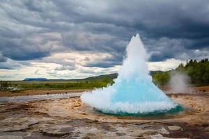 berühmter strokkur-brunnen-geysir heißer blauer wasserausbruch mit wolkenhimmel und umgebender isländischer landschaft, island foto