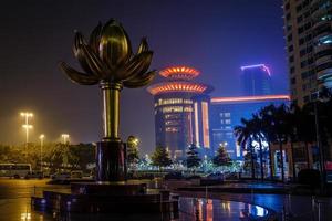 lotusplatz mit bronzeblume das unabhängigkeitssymbol von macau und neonlichter der umliegenden gebäude, china