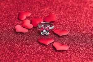 willst du mich heiraten. Ehering und viele rote Herzen auf rotem Glitzerhintergrund. Verlobung Heiratsantrag Hochzeitskonzept. st. Valentinstag Postkarte. Banner am Valentinstag. foto