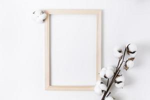 Holz Fotorahmen mit Baumwollblume und weißem Stoff auf weißem Hintergrund foto