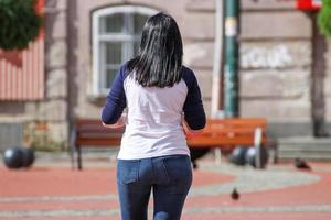 Frau, die an einem sonnigen Tag auf der Straße geht foto