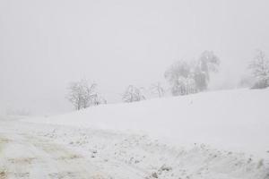 verschneite winterstraße in der bergregion nach starkem schneefall in rumänien foto