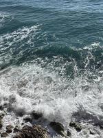 die Wellen im Meer krachen gegen die Felsen foto