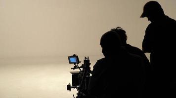 silhouette von arbeitenden menschen oder produktionsfilmteams machen filme oder drehen. foto