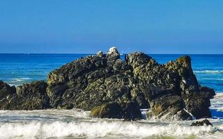 schöne felsen klippen surfer wellen am strand puerto escondido mexiko. foto