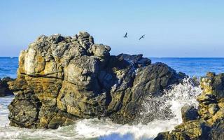 schöne felsen klippen surfer wellen am strand puerto escondido mexiko. foto