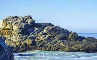 schöne felsen klippen surfer wellen am strand puerto escondido mexiko. foto