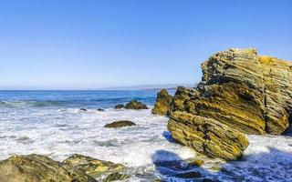 schöne felsen klippen surfer wellen am strand puerto escondido mexiko. foto