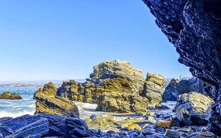 schöne felsen klippen surfer wellen am strand puerto escondido mexiko. foto