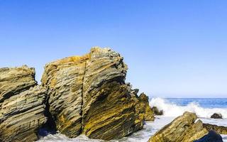 schöne felsen klippen surfer wellen am strand puerto escondido mexiko. foto