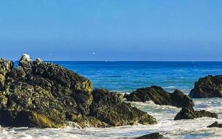 schöne felsen klippen surfer wellen am strand puerto escondido mexiko. foto