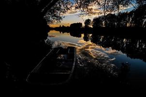 Boot auf dem Fluss bei Sonnenuntergang foto