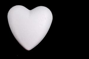 weißes Herz auf schwarzem Hintergrund foto