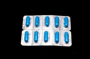 blaue Pillen auf schwarzem Hintergrund foto