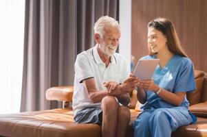 krankenschwester lehrt senior, tablet zu verwenden foto