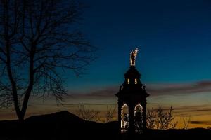 Kirche eines Bergdorfes in den italienischen Alpen bei Sonnenuntergang foto