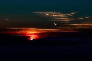 Sonnenuntergang mit Feuersonne in den dunklen Bergen foto