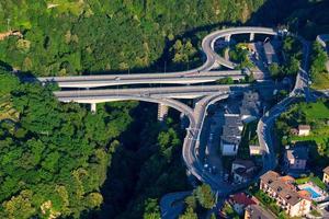 Blick aus dem hohen Winkel auf Straßen- und Querbrücken in der Natur des Waldes in der Nähe des Lecco-Sees, Italien foto