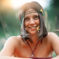 Porträt eines Mädchens im Woodstock-Hippie-Stil. mit Blume im Mund foto