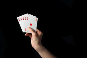 Spielkarten in der Hand isoliert auf schwarzem Hintergrund foto