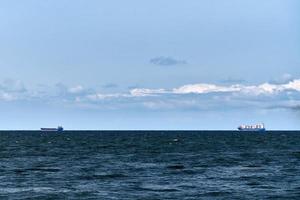 containerfrachtschiffe frachter in der ferne, import export logistik, frachtschiffe im blauen meer foto