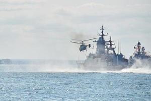 schlachtschiffe kriegsschiffe korvette während marineübungen und hubschrauber manövrieren über meer, kriegsschiffe foto