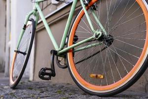 Ein Stadtrad, das an der Wand eines Cafés in der Stadt geparkt ist, mit dem Fahrrad zur Arbeit fährt, ein stilvolles Fahrrad in einer städtischen Umgebung foto