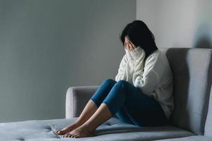 Konzept der traurigen Teenager-Depression. Umgekipptes Teenager-Mädchen, das drinnen am Fenster sitzt. angst junge frau verzweiflung und stress. Einsame und unglückliche Frauen sind soziale Opfer. Einsamkeit Jugend zu Hause. foto