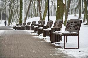 schneebedeckte Bänke im Winterpark foto
