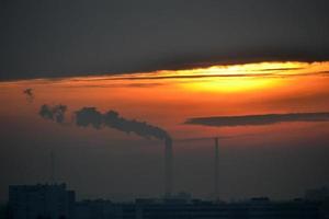 Rauch aus dem Fabrikschornstein bei Sonnenuntergang foto