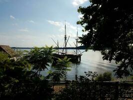 Altes Boot, das am Fluss- oder Seewasser angedockt ist foto