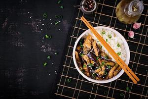 Pfannengerichte mit Huhn, Auberginen und gekochtem Reis - chinesisches Essen. Ansicht von oben foto