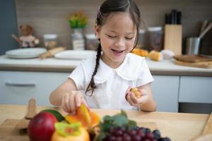 Das Kind spielt Obst. Kinder, die auf Spielzeugküchenkochen liegen. Kinder pädagogische, kreative Spiele. foto