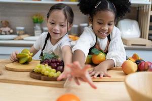 Das Kind spielt Obst. Kinder, die auf Spielzeugküchenkochen liegen. Kinder pädagogische, kreative Spiele. foto