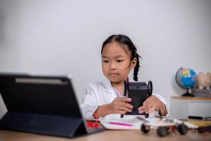 asiatische schüler lernen zu hause, indem sie roboterautos und elektronische platinenkabel in stamm, dampf, mathematik, ingenieurwesen, wissenschaft, technologie, computercode in robotik für kinderkonzepte codieren. foto