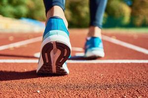 blaue Sportschuhe auf der Stadionbahn foto