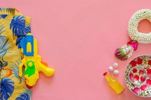 Songkran Festival Hintergrund mit Blumen und duftendem Wasser, um Segen und Accessoires zu geben, um Wasser auf rosa Hintergrund zu spielen. foto