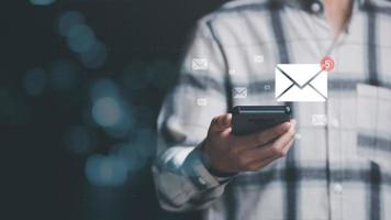 Mann liest E-Mail vom Smartphone, E-Mail-Marketing und Newsletter-Konzept, digitale Kommunikation mit E-Mail-Nachrichten, Senden und Empfangen von Nachrichten online mit dem E-Mail-Symbol foto