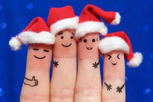 finger art of friends feiert weihnachten. das konzept einer gruppe von menschen, die in neujahrshüten lachen. foto